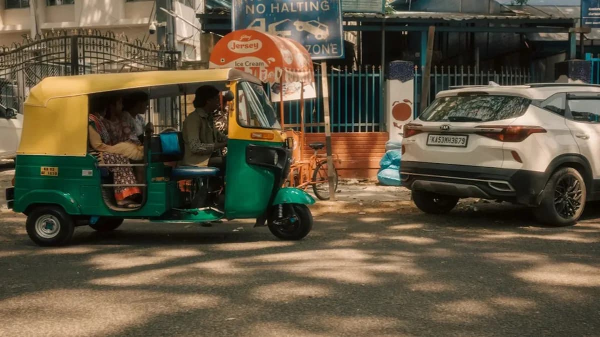 Green and yellow auto rickshaw driving on a bengaluru street